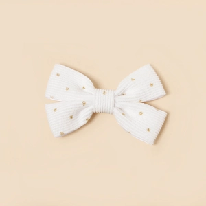 Détail du nœud papillon en velours côtelé blanc avec paillettes dorées pour filles