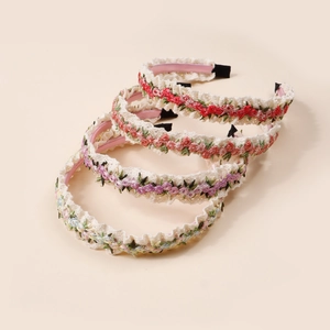 Détail de quatre bandeaux en dentelle à broderie florale pour filles en couleurs pastel