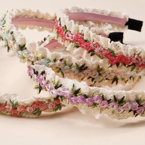 Détail de serre-têtes en dentelle brodée avec des fleurs au crochet pour fillettes