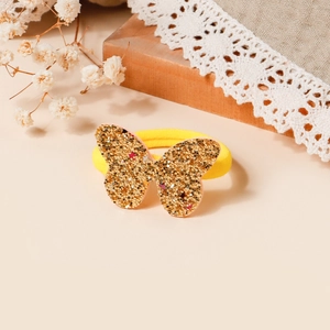 Dettaglio dell'elastico per capelli giallo con ornamento a farfalla di paillettes dorate