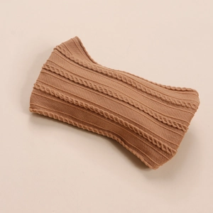 Détail de la texture en maille torsadée caramel sur un bandeau souple en nylon pour bébé