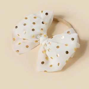 Detailed close-up of white mesh baby headband with gold sequins and elastic nylon band