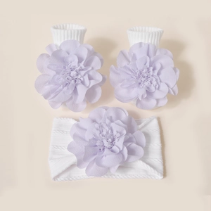 Détail de chaussettes et bandeau bébé avec de grandes fleurs en tissu tricoté violet