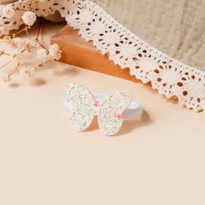 Dettaglio dell'elastico per capelli con farfalla di paillettes colorate per bambine su pizzo