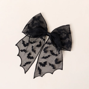 Detailed macro view of black lace hair bow with bat patterns for Halloween hair styling