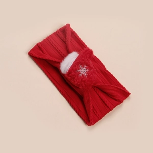 Détail d'un bandeau rouge tricoté pour bébé avec un bas de Noël en peluche et un flocon