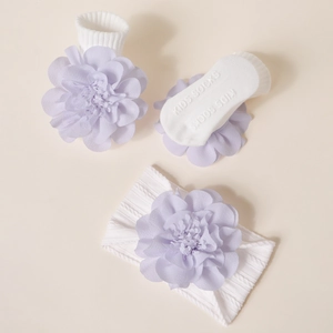 Détail de chaussettes bébé avec fleurs en mousseline violette et semelle antidérapante