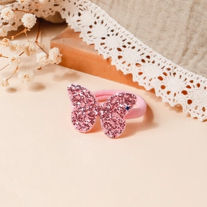 Dettaglio dell'elastico per capelli con farfalla di paillettes rosa per bambina con decoro