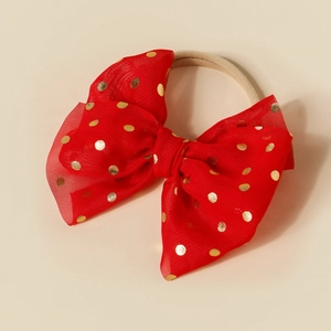 Detailed view of a red mesh bow headband with golden foil polka dots for babies