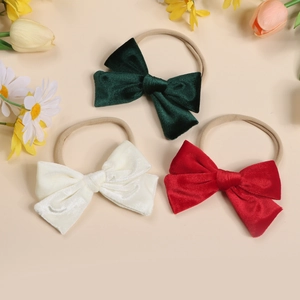 Three-piece set of velvet baby bow headbands in dark green, cream white, and red colors