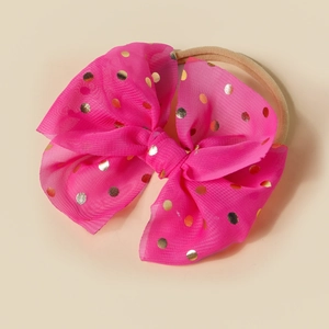 Detailed view of oversized pink tulle bow headband with shiny metallic gold dots