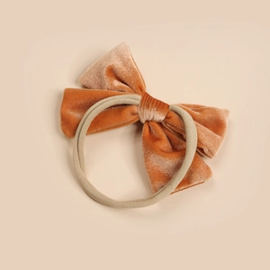 Macro shot of caramel velvet bow headband with high-stretch nylon band for baby girl