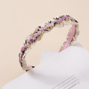 Gros plan du serre-tête en satin rose avec broderie en dentelle blanche et fleurs