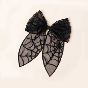 Detail of Halloween black lace bow clip featuring translucent spider web mesh pattern