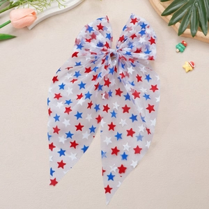 Détail d'un nœud papillon en tulle avec motifs étoiles sur un fond texturé beige