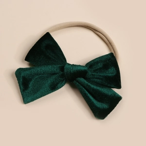Close-up of soft dark green velvet bow headband with high-elastic nylon strap for babies