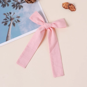 Detail der rosa Baumwoll-Schleife mit natürlicher Leinenstruktur auf beige Hintergrund