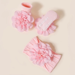 Détail d'un ensemble bébé rose avec bandeau fleuri 3D et chaussettes antidérapantes pour nouveau-nés