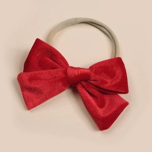 Detail of red velvet bow on soft nylon elastic headband for baby girls
