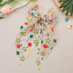 Détail de barrette à cheveux nœud de Noël en mesh avec motifs flocons et rubans festifs