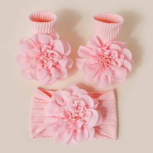 Détail d'un ensemble bandeau et chaussettes tricotés roses pour bébé avec fleurs 3D