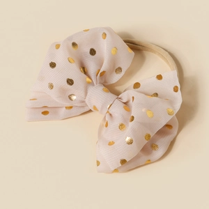 Detail of soft nylon infant headband with sequin gold polka dot bow in light pink
