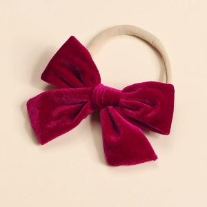 Detail of soft dark red velvet bow with elastic nylon headband for babies and toddlers