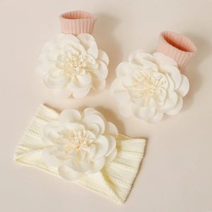 Détail d'un ensemble bandeau et chaussettes pour bébé avec grandes fleurs 3D