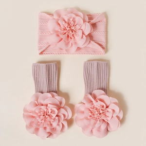 Détail d'un bandeau en tricot pour bébé et de chaussettes assorties avec fleurs 3D