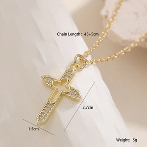 Vue macro du collier croix dorée avec zircons montrant les dimensions 2,7x1,5cm