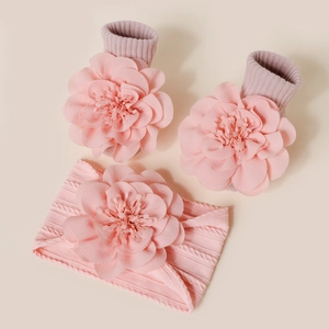 Détail du bandeau et des chaussettes tricotés pour bébé avec fleurs 3D roses vintage