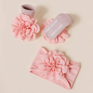 Détails d'ensemble chaussettes et bandeau bébé tricotés avec grandes fleurs en tissu 3D