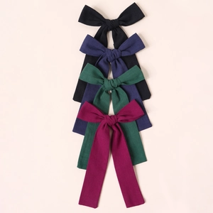 Detailansicht von vier strukturierten Haarschleifen in Schwarz, Navy, Waldgrün und Weinrot