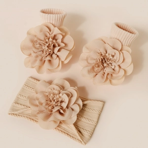 Vue détaillée du bandeau et des chaussettes bébé tricotés avec fleurs 3D en rose chair