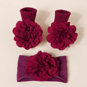 Détail du set de chaussettes et bandeau en tricot pour bébé avec grandes fleurs 3D