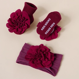 Détail de l'ensemble bandeau et chaussettes en tricot bordeaux pour bébé avec fleurs