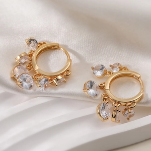 Élégantes créoles plaquées or 18 carats avec zircons pendants sur de la soie blanche
