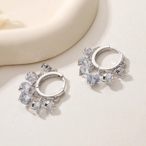 Détail de boucles d'oreilles en argent plaqué or 18K avec cinq zircons étincelants