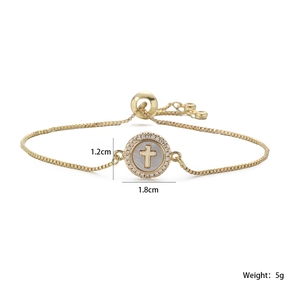 Detail of 18K gold-plated bracelet with mother of pearl cross charm and cubic zirconia