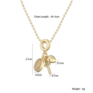 Détail du collier à billes plaqué or 18K avec médaillon, cœur et croix pendentifs