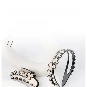 Detail of beige acetate flower hair claw and headband set with elegant white pearls