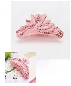 Vue détaillée d'une grande pince à cheveux en acrylique rose avec strass et motif