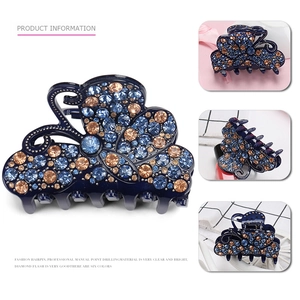 Sparkling butterfly hair claw clip with blue and champagne rhinestones on a dark blue base