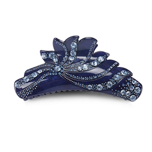 Détail de la pince à cheveux en éventail avec des strass bleu clair sur fond bleu foncé