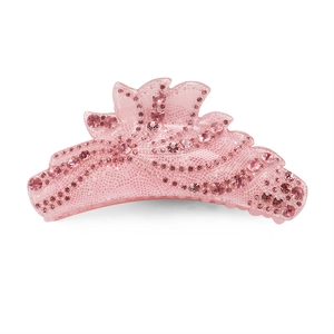 Détail d'une pince à cheveux rose ornée de strass et d'un motif ondulé élégant