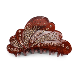 Detailed view of brown acrylic hair claw clip featuring sparkling amber rhinestones