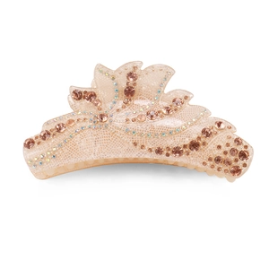 Détails d'une pince à cheveux beige avec strass brillants et texture quadrillée