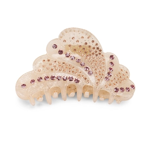 Detail of beige acrylic hair claw clip with pink rhinestones and gold rivets design