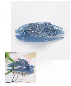 Dettaglio della pinza per capelli in acrilico blu a forma di foglia con strass