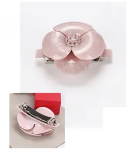 Détails d'une pince à cheveux fleur de camélia rose en acrylique avec diamant autrichien